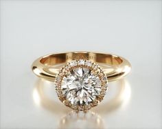 a rose gold engagement ring with a round diamond center