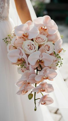 a bride holding a bouquet of pink flowers