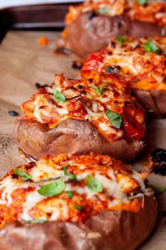 several baked pizzas are lined up on a cutting board