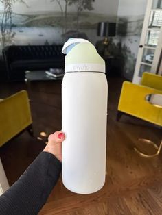 a person holding a white water bottle in their hand