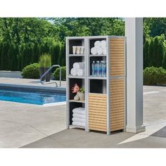 an outdoor storage unit with towels and other items in front of a swimming pool area