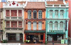 several buildings are painted in different colors on the street