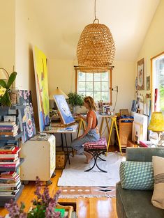 a woman sitting at a desk in an art studio