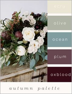 a vase filled with flowers and greenery on top of a wooden table next to a wall