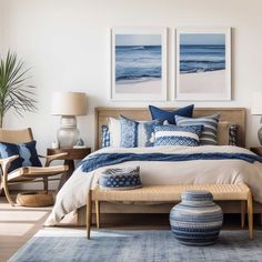 a bedroom with blue and white decor on the bed, two pictures above the bed