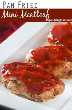 two meatloaf patties covered in ketchup on a white square plate