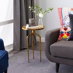 a living room with a couch, chair and vase on the table in front of it