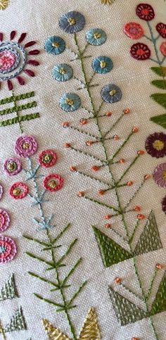 a close up of a cross stitch pattern with flowers and leaves on the bottom half