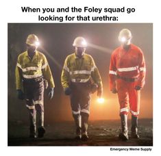 three men in safety gear walking through the dark