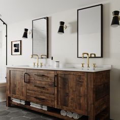 a bathroom with two sinks and mirrors on the wall