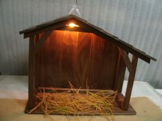 a small wooden nativity scene with a star above the manger and straw in front of it