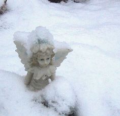 an angel statue is covered in snow on the ground