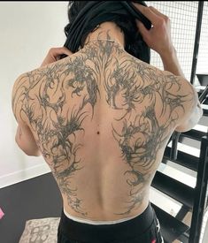 the back of a man with tattoos on his body