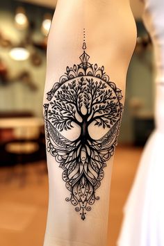 a woman's leg with a tree tattoo on the lower part of her body