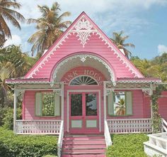 a pink house with white trim on the front door and steps leading up to it