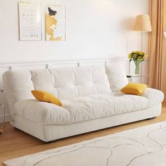 a white couch sitting in a living room next to a window