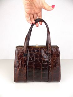 "Vintage 1950's 1960's structured handbag in brown animal leather and lined in rayon fabric.  Good vintage condition with minor wear. There is some wear to the hardware and on the handles. See detail photos. Measures 7\" high x 7 1/2\" wide; 3\" width at side; handle 4 1/2\" high" 1960s Bags Vintage Handbags, Classic Brown Evening Bag For Formal Occasions, Classic Brown Formal Evening Bag, Formal Brown Satchel, Vintage Rectangular Evening Bag For Shopping, Brown Formal Evening Bag With Top Carry Handle, Brown Formal Evening Bag With Top Handle, Formal Brown Evening Bag With Top Carry Handle, Formal Brown Box Bag