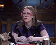 a woman in glasses sitting at a table