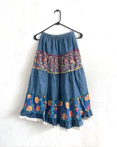 Amazing vintage high-waisted vintage denim skirt with colorful printed floral and paisley panels with a lace trim on the bottom. Waist is elastic. Label: Trousers Up Decade: 1970s Condition: Excellent Materials: 100% Cotton  Marked Size: Small True Size: Small Measurements: 22 inch waist (elastic) 30.5 inches long Check out our full collection at totalrecallvintage.com and follow @totalxrecall on Instagram to keep up with new items, sales and more! 70s Jean Skirt, Bohemian Blue Denim Skirt, Blue Bohemian Denim Skirt, 70s Floral Skirt, 1970’s Skirt, Vintage Denim Skirt, Vintage Fringe, Skirt Y2k, Womens Maxi Skirts