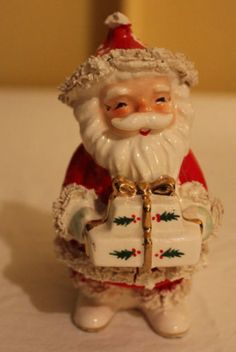 a santa clause figurine holding a present