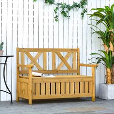 a wooden bench sitting next to a potted plant