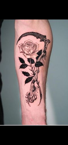 a black and white rose tattoo on the right leg with an arrow in it's center