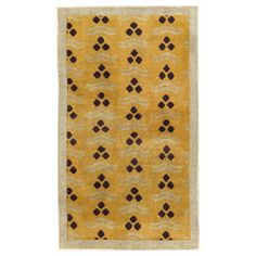 a yellow rug with brown and black designs on it, against a white background the rug is made out of wool