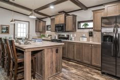 a large kitchen with wooden cabinets and an island in the middle, along with stainless steel appliances