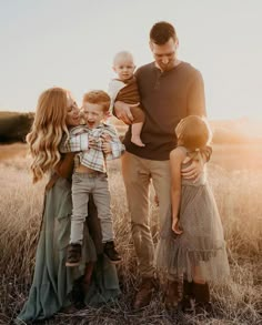 a family standing in a field at sunset