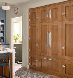 a kitchen with wooden cabinets and an island in front of the door that leads to another room