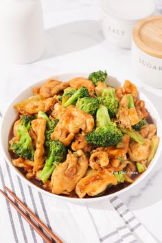 chicken and broccoli stir fry in a bowl with chopsticks on the side