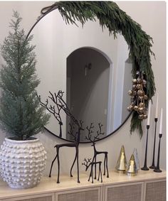 a mirror sitting on top of a dresser next to a christmas tree and other decorations