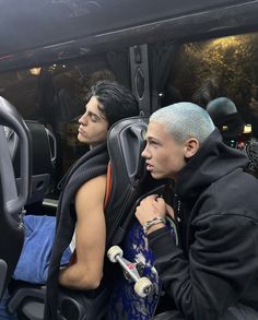 two young men sitting in the back of a bus