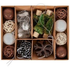 an open box filled with different types of christmas balls and ornaments, including pine cones