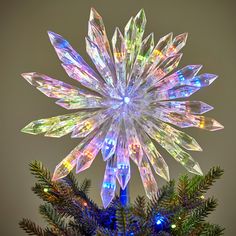 a christmas tree decorated with multicolored lights and snowflaked decorations on top