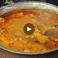 a large pot filled with food on top of a wooden table next to a spoon