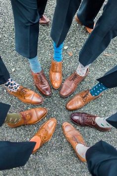 a group of people standing in a circle wearing dress shoes