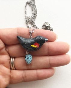 "This Elegant Red Winged BlackBird Necklace is hand made from polymer clay and carefully painted with fine detail. It was then given two coats of satin varnish to give it a protective finish. Though made from clay, The shine on it makes it look like glass! Charm size including dangle Egg-          1\" in length 1\" in width This charm necklace includes: -safe oven hardened polymer clay -The charm is secured onto a stainless steel 18\" long chain, lobster clasp necklace! The necklace is 2mm in wi Bird Watcher Gifts, Bird Necklace, Elegant Red, Bird Jewelry, Gifts For Nature Lovers, Bird Lovers, Black Bird, Charm Jewelry, Charm Necklace