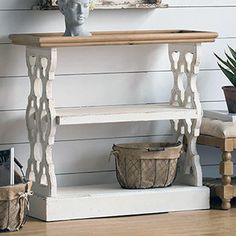 a white shelf sitting next to a potted plant on top of a wooden table