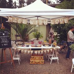 a man standing in front of a table with food on it under a white tent