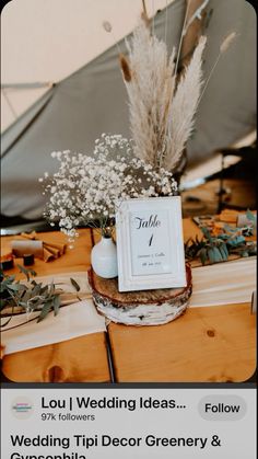 a table topped with a vase filled with flowers next to a sign that says wedding ideas