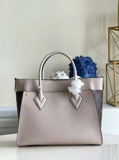 The On My Side MM tote bag is fashioned from an elegant combination of small-grained calf leather and emblematic Monogram canvas. The large outside pockets in contrasting canvas create a bag-in-a-bag look. The roomy interior can easily hold everything needed for a day at the office while the adjustable strap makes for practical cross-body carry. Detailed Features 30.5 x 24.5 x 14 cm (Length x height x width ) Greige Calfskin and Monogram coated canvas Cowhide-leather trim Microfiber lining Gold- Day At The Office, Magnetic Lock, My Side, Vuitton Bag, Monogram Canvas, Cowhide Leather, The Office, Leather Trims, Calf Leather