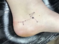 a small star tattoo on the foot of a woman's left foot, which is decorated with tiny stars