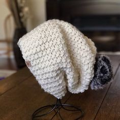 a white crocheted hat on top of a wooden table