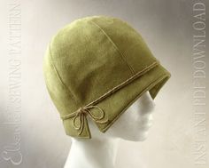 a mannequin's head wearing a green hat with a knot on it