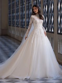 a woman in a wedding dress is posing for the camera with her hands on her hips