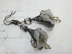 GOTHIC WHITE FLORAL EARRINGS ▪️▪️▪️▪️▪️▪️▪️️▪️▪️▪️▪️▪️▪️ These hand painted fluted Lucite flowers have been combined with bronze filigree to create these beautiful vintage gothic inspired drop earrings. Faceted clear crystals have been added for beautiful sparkle when they move and they are finished with fish hook ear wires. They are very light weight and are perfect for special occasions yet cute enough for everyday wear.          💜MATERIALS             *White Lucite flowers   *Bronze earring White Flower Earrings, White Flower Earring, Pink Gift Box, Flower Dangle Earrings, Earrings Halloween, Bronze Earrings, Bohemian Accessories, Motif Vintage, Vintage Gothic