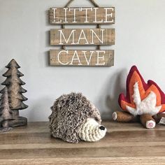 there is a stuffed hedge sitting on the shelf next to other toys and decorations, including a sign that says little man cave