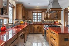 a large kitchen with marble counter tops and wooden cabinetry, along with an island