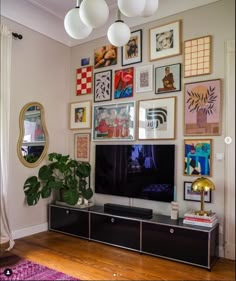 a living room with pictures on the wall and a large flat screen tv mounted to the wall